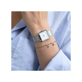 Entièrement argentée et blanche, la montre Claire incarne la sobriété chic. Elle allie simplicité, raffinement et style, pour un look intemporel et lumineux.