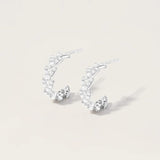 Les créoles Jula en Or blanc sont de véritables bijoux délicats et étincelants. Chaque oxyde est soigneusement serti, créant un éclat subtil et élégant. Les créoles Jula apportent une touche de glamour discret à votre style, encadrant délicatement votre visage avec leur design classique et intemporel.