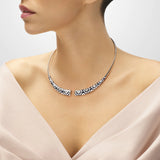 Torque en argent Aztec Una Storia, un bijou inspiré par la culture aztèque. Fabriqué en argent massif rhodié, il est laqué à la main et incrusté d'oxydes de zirconium. Fait partie de la collection de bijoux aztèques pour femme, ce collier est idéal pour une occasion spéciale. Associez-le au jonc été bleu et blanc en argent pour un ensemble harmonieux.