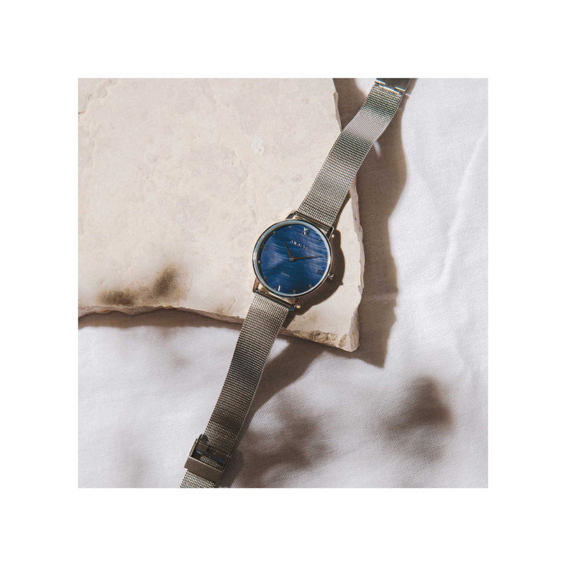 la montre Aurore, tout en argent et son cadran bleu nacré aux reflets subtils, est définitivement l'accessoire à avoir pour compléter son look.
