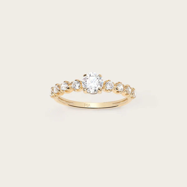 Bague SIA : Un solitaire en Or jaune magnifié par des oxydes délicatement sertis sur les côtés. Cette bague incarne l'élégance subtile et le raffinement. Parfaite pour toutes les occasions, elle ajoute une touche de glamour intemporel à votre style, attirant les regards avec son éclat étincelant.