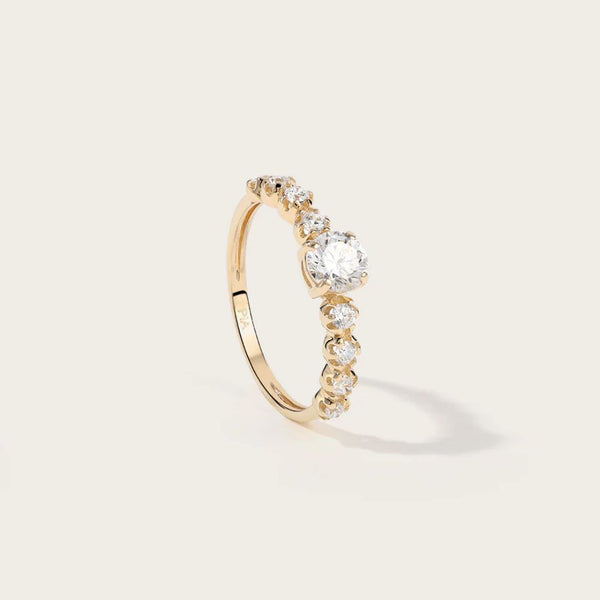 Bague SIA : Un solitaire en Or jaune magnifié par des oxydes délicatement sertis sur les côtés. Cette bague incarne l'élégance subtile et le raffinement. Parfaite pour toutes les occasions, elle ajoute une touche de glamour intemporel à votre style, attirant les regards avec son éclat étincelant.