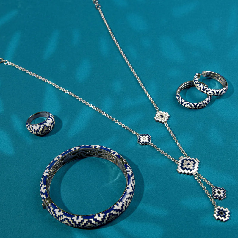 Pendentif Una Storia, inspiré par la culture aztèque, en argent 925 rhodié. Son imprimé graphique bleu rappelle l'obsidienne. Associez-le à une chaîne, un cordon ou un câble en argent pour un collier unique. Complétez avec la bague et les boucles d'oreilles de la collection Aztec. Un accessoire polyvalent pour différentes tenues, serti d'oxydes de zirconium.