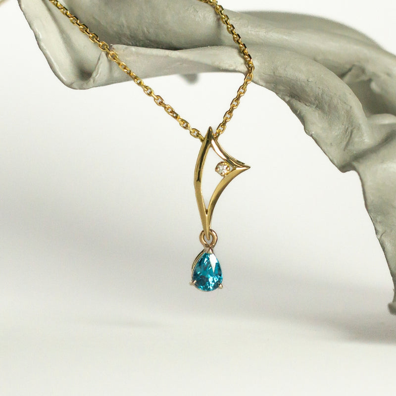 Le pendentif Stella en or 18 carats est un bijou élégant et raffiné. Le zircon bleu étincelant, et le diamant créant un contraste fascinant.